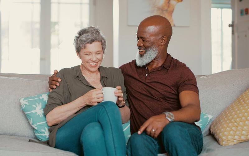 smiling, older couple, sit together on a couch