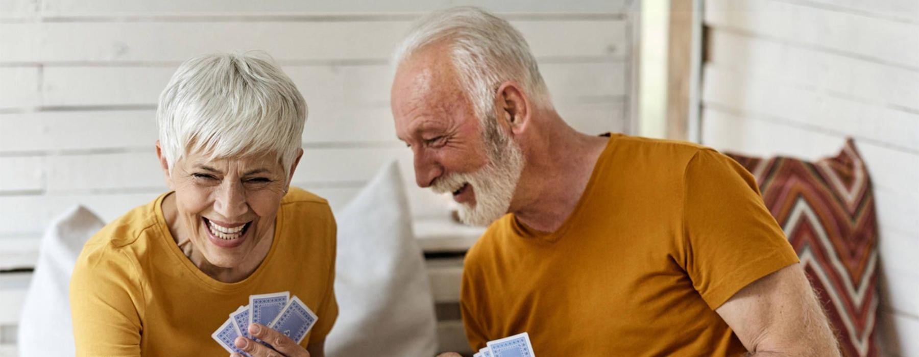 a man and woman sitting at a table playing cards